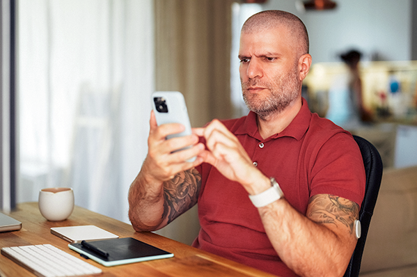 man looking at his phone with a concerned look